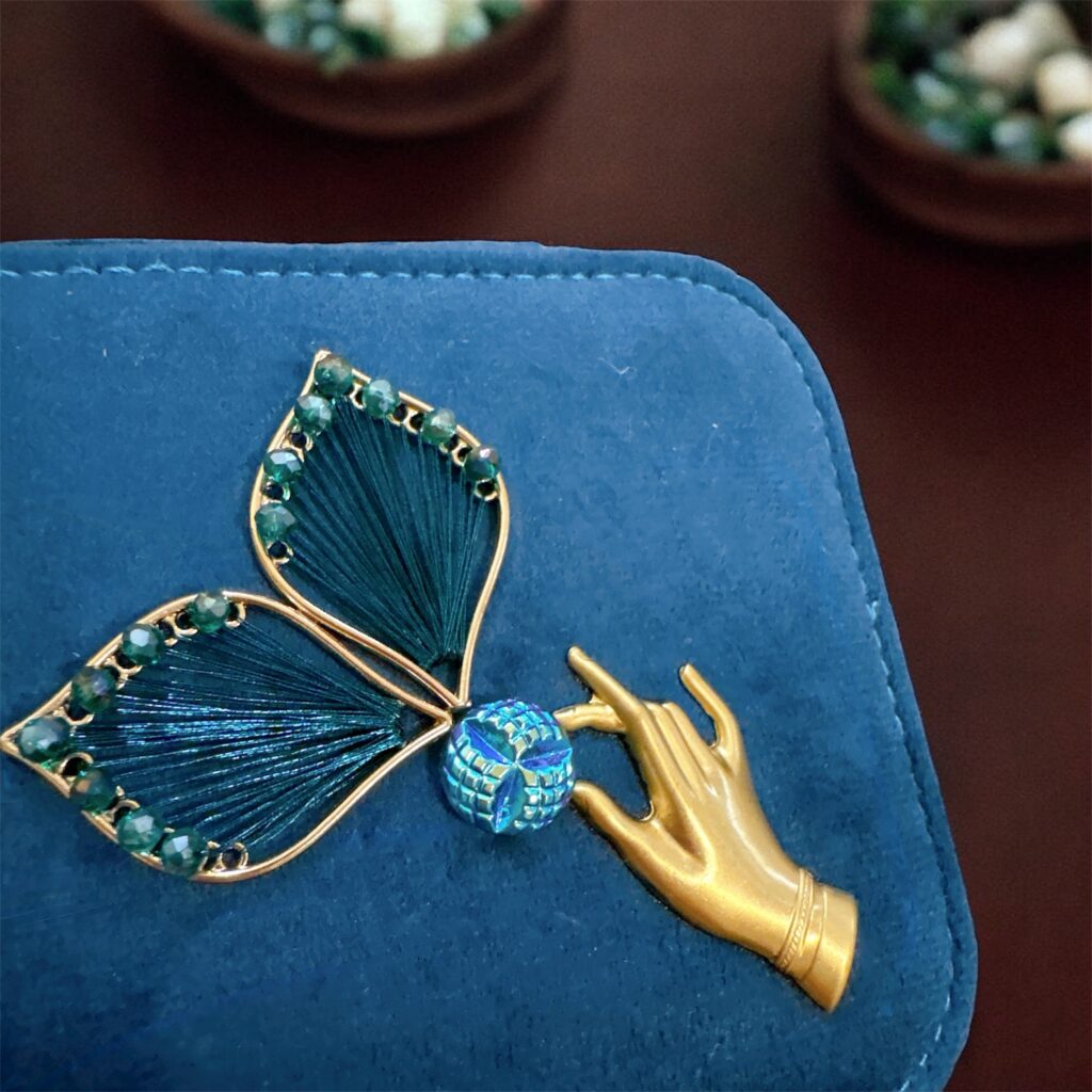 フェアリーの羽根と手のモチーフがあしらわれたティールブルーのジュエリーケース。チェコガラスの煌めきが特徴のFairy Realm Collection。