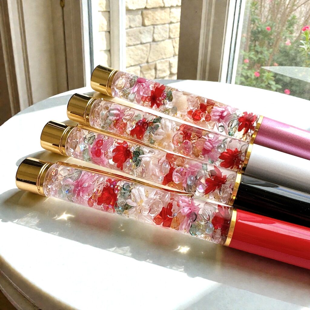 4色のRosette Bloomハーバリウムボールペンを窓辺の光の中で並べた写真