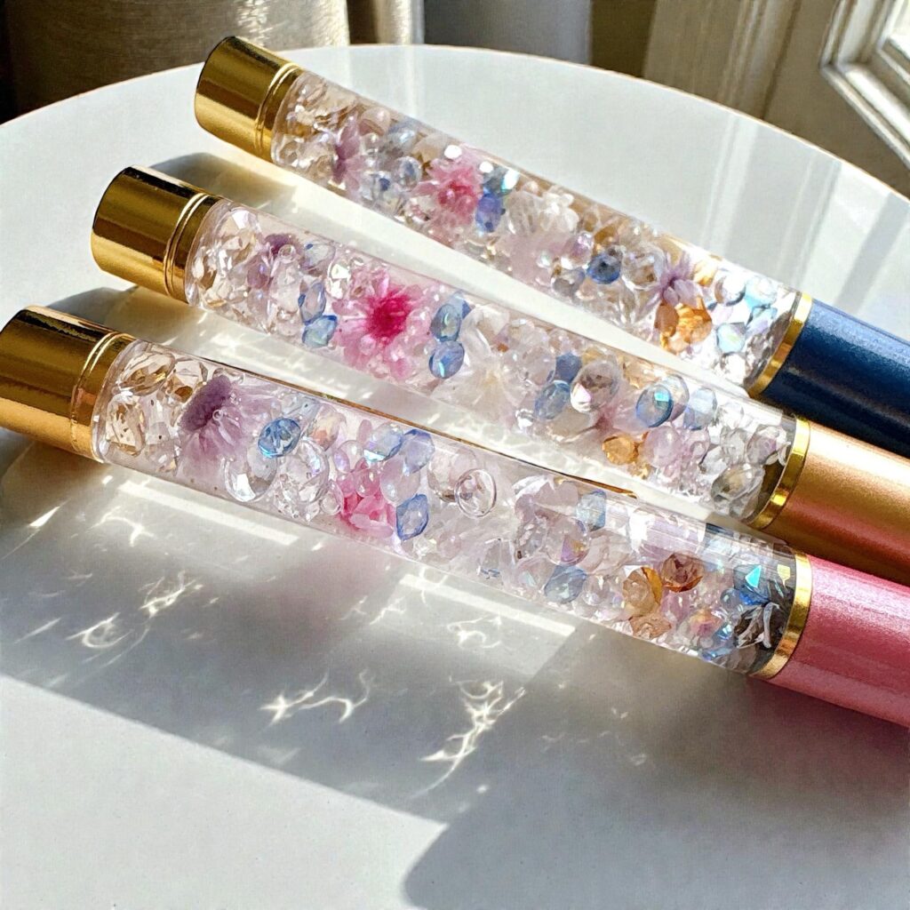 Moonlit Bloom｜透明感あふれる花材とガラスの煌めきが混ざり合うハーバリウム部分のクローズアップ。月の光にふれたような淡いブルーとピンクの輝き。