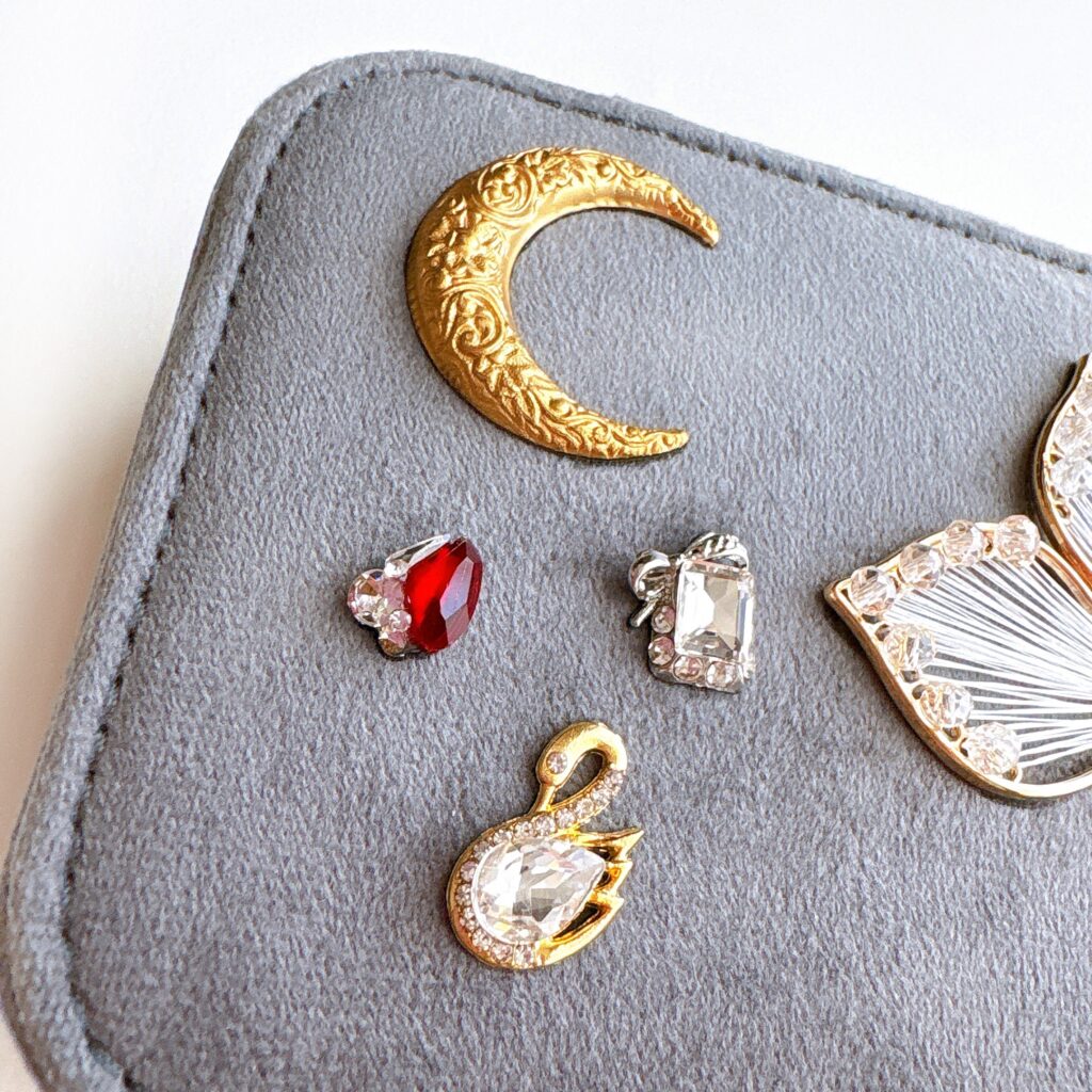 アンティーク調の三日月モチーフとチェコガラス装飾をあしらったジュエリーケースの蓋ディテール。静けさと時間の流れを象徴するFairy Realm Collection作品。

Close-up of an antique-style crescent moon ornament with Czech glass decoration on a jewelry box lid, symbolizing quiet time and calm elegance from the Fairy Realm Collection.
