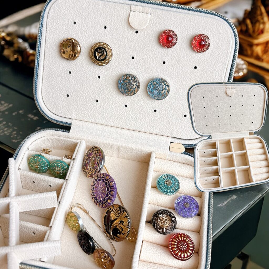 仕切り付きのジュエリーケース内部。チェコガラスアクセサリーやリング、ピアス、イヤリング、ブレスレットなどを整理して収納できる設計の宝石箱。Fairy Realm Collection作品。

Interior of a jewelry box with compartments designed to organize Czech glass accessories, rings, earrings, and bracelets, from the Fairy Realm Collection.
