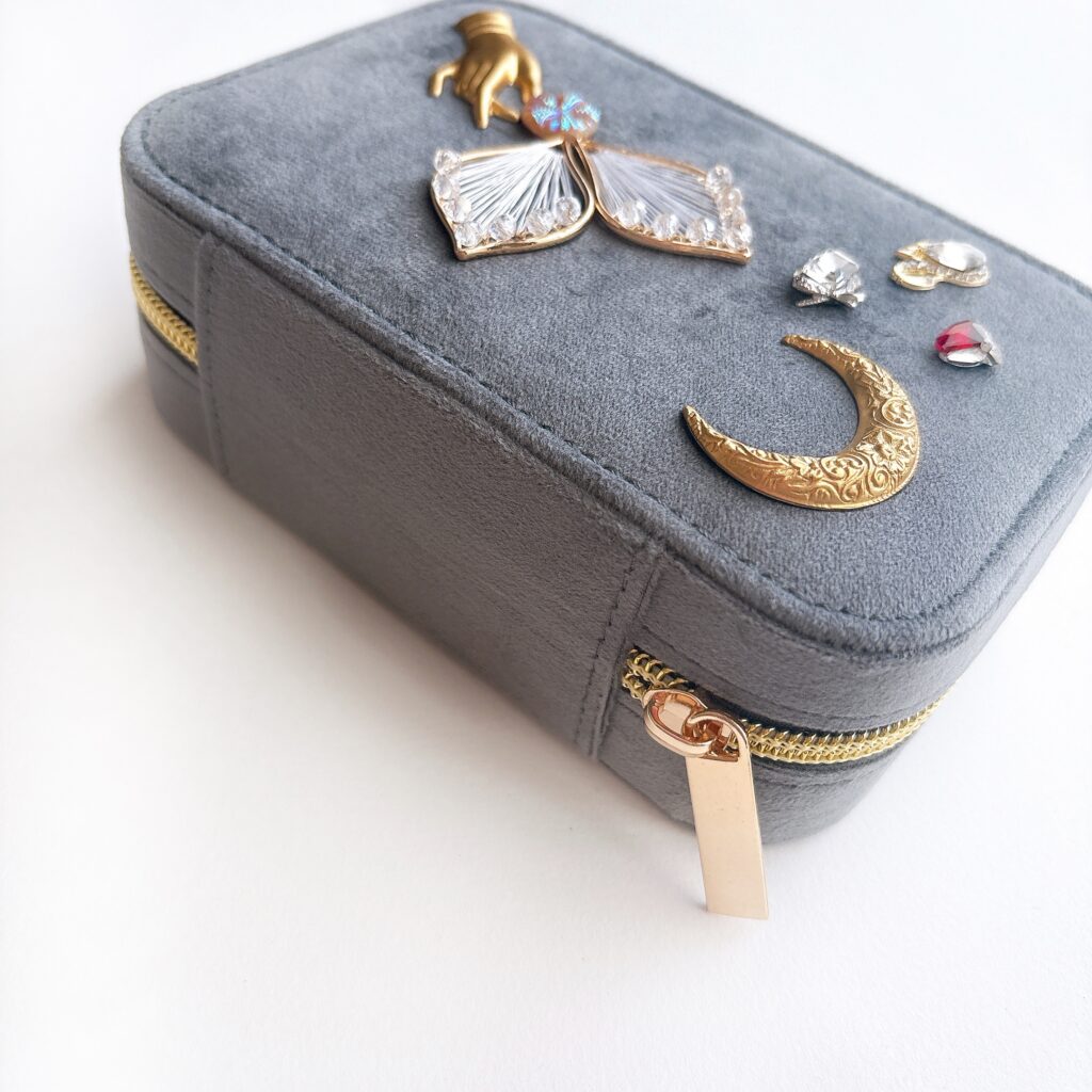 アースグレーのベルベット調ジュエリーケースにチェコガラス装飾を施した宝石箱。Fairy Realm Collection作品。

An earth grey velvet jewelry box decorated with Czech glass ornaments from the Fairy Realm Collection.