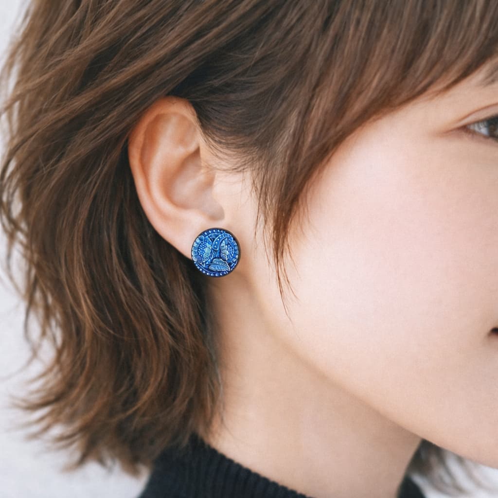 耳元に着用した蒼い花モチーフのチェコガラスイヤリング。深い青がさりげなく輝くデザイン