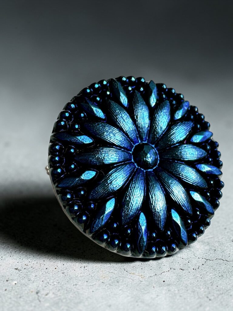 蒼い花モチーフのチェコガラスブローチ。光の角度で深い青が浮かび上がるデザイン