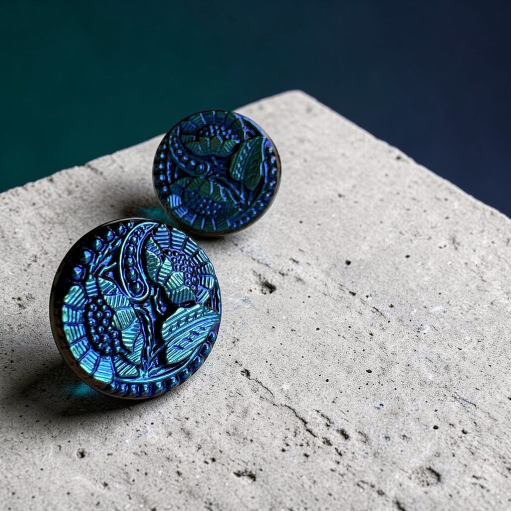 蒼い花モチーフのチェコガラスアクセサリーを2つ並べた構図。光で異なる青の表情が見えるデザイン