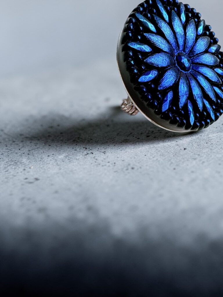 深い青のチェコガラスの模様をクローズアップした一枚。光を受けて浮かび上がる繊細な柄が、静かで奥行きのある輝きを生み出している。